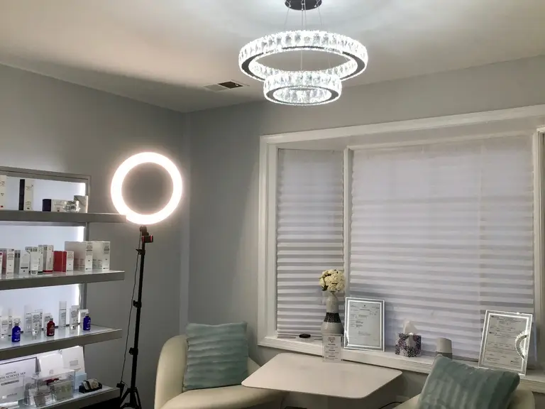 Consultation table beside the lit skincare shelf and ring light