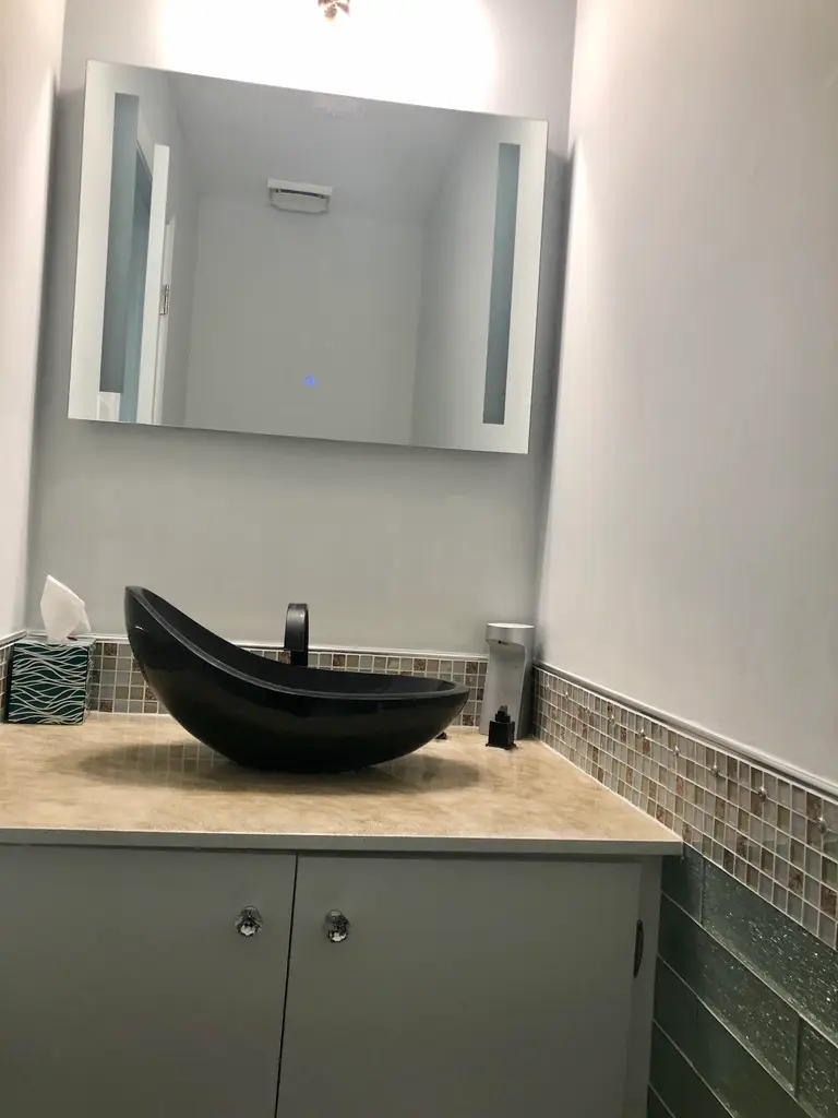 Guest washroom with vessel sink and glass mosaic tile